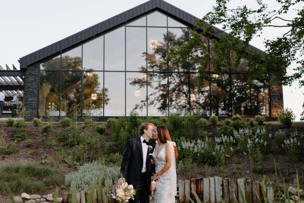 Bride and groom portrait featuring exterior of Everhart gathering place