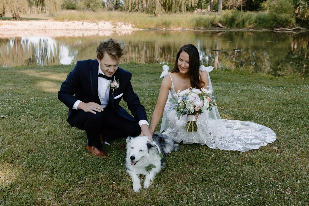 A dog included in wedding portraits with the bride and groom