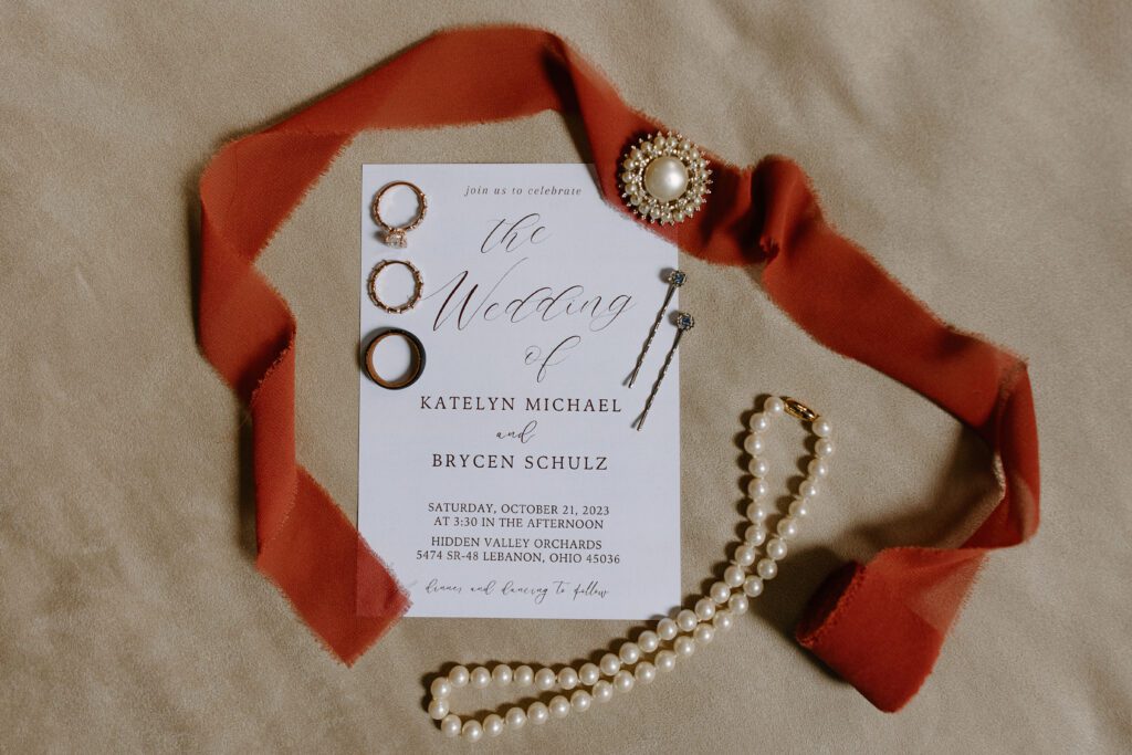 Wedding detail photos featuring invitation, rings and jewelry