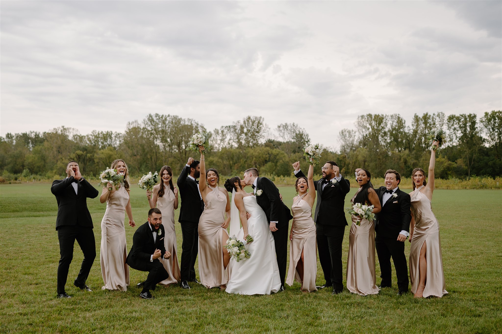 Wedding party photo of everyone cheering at Birchwood Meadow